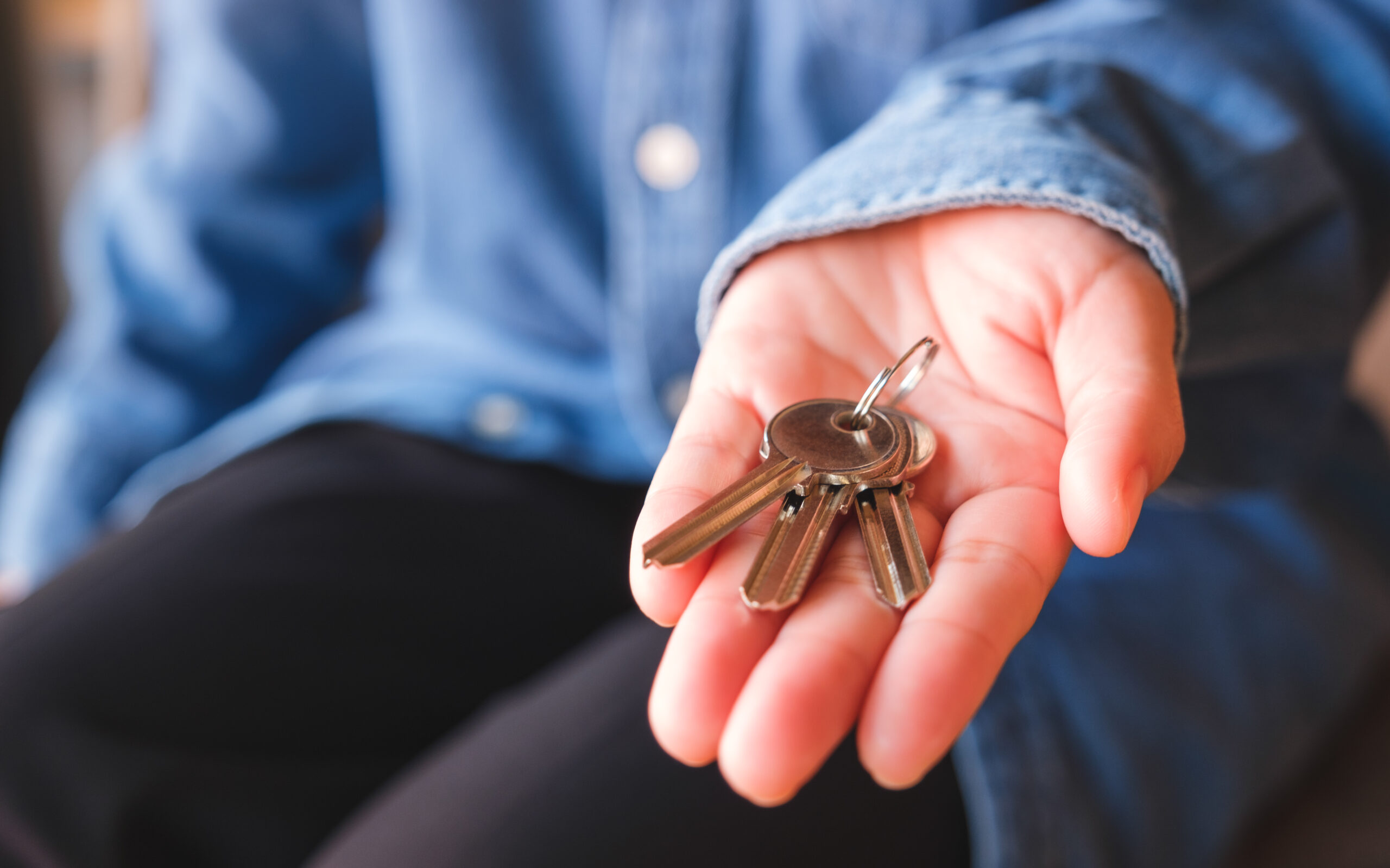 Closeup image of a hand holding the keys for real estate